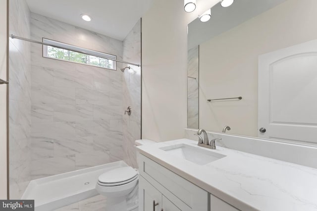 bathroom with tiled shower, tile flooring, vanity, and toilet