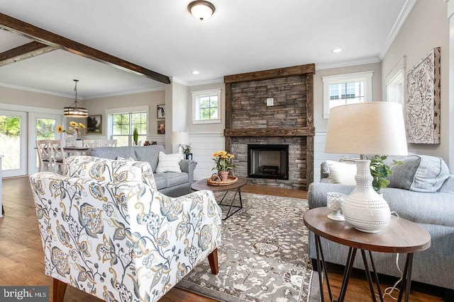 living room featuring hardwood / wood-style flooring, a fireplace, and crown molding