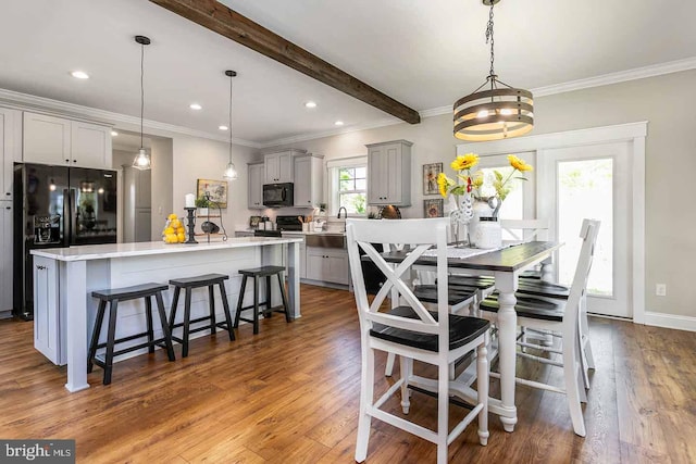 dining space featuring beamed ceiling, crown molding, and dark hardwood / wood-style flooring