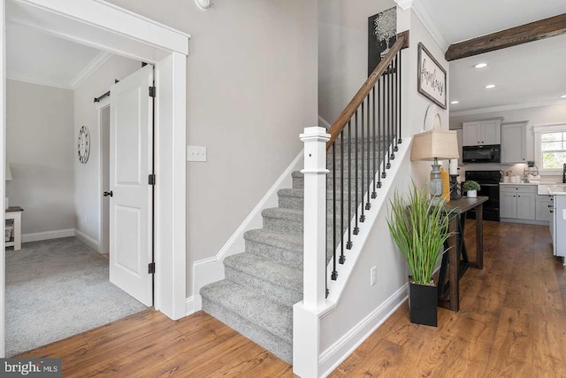 staircase featuring hardwood / wood-style floors and crown molding