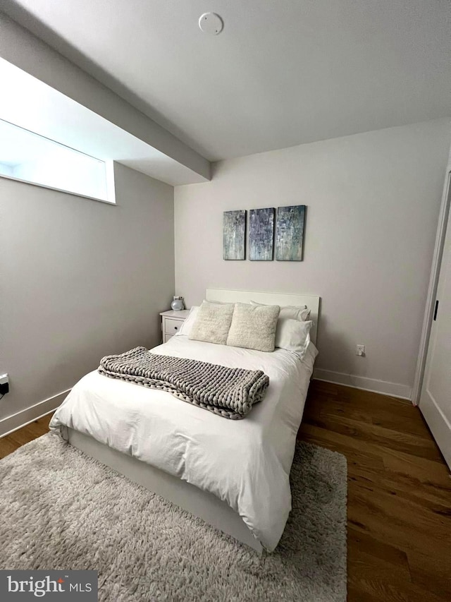 bedroom with dark hardwood / wood-style flooring