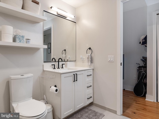 bathroom with wood-type flooring, vanity, and toilet