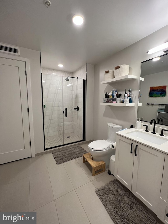 bathroom with tile patterned flooring, vanity, toilet, and a shower with door