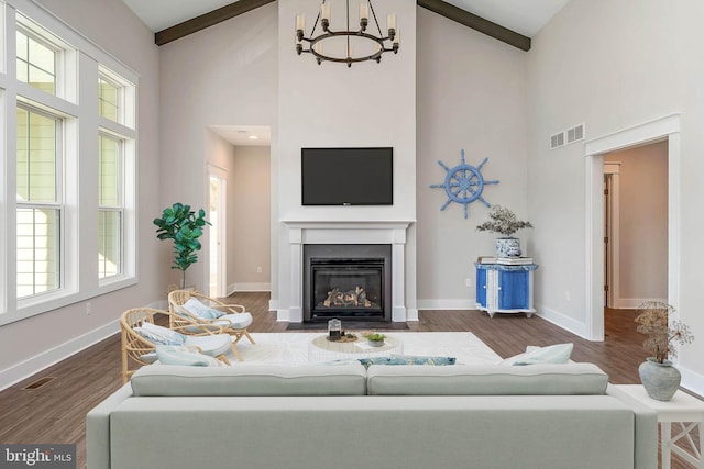 living room with a healthy amount of sunlight, dark hardwood / wood-style flooring, and high vaulted ceiling