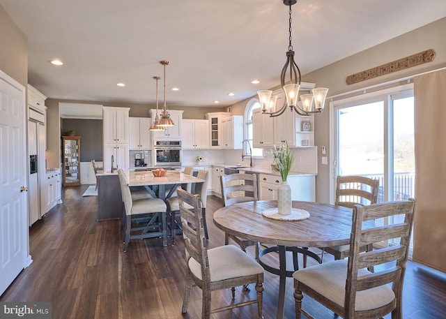 dining room with an inviting chandelier, sink, and dark hardwood / wood-style flooring