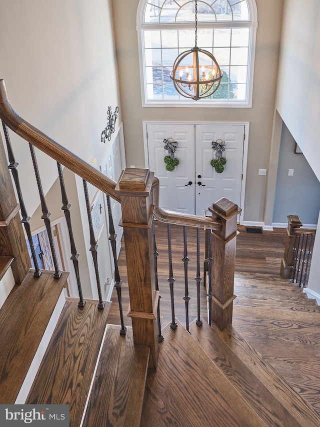 entrance foyer with wood-type flooring, a high ceiling, and a chandelier