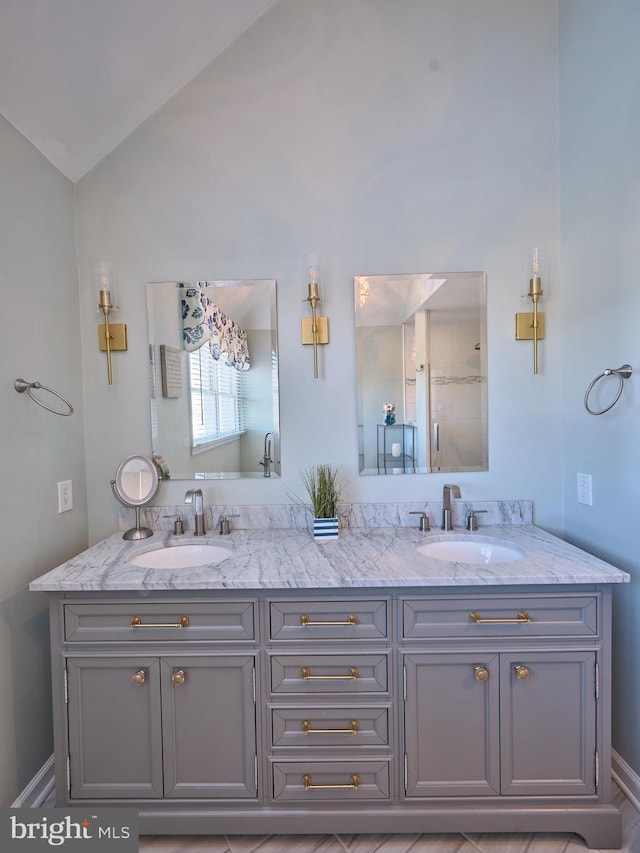 bathroom featuring double sink vanity and vaulted ceiling