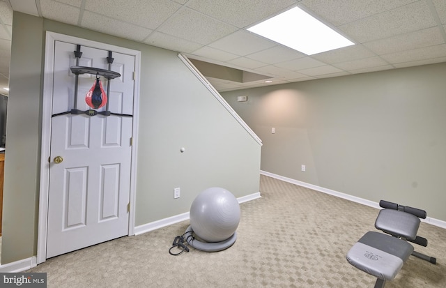 workout area featuring carpet floors and a paneled ceiling