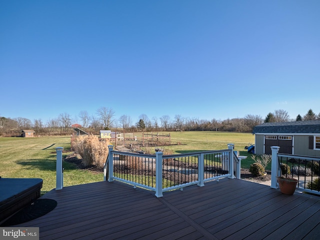 wooden deck featuring a rural view, an outdoor structure, and a lawn