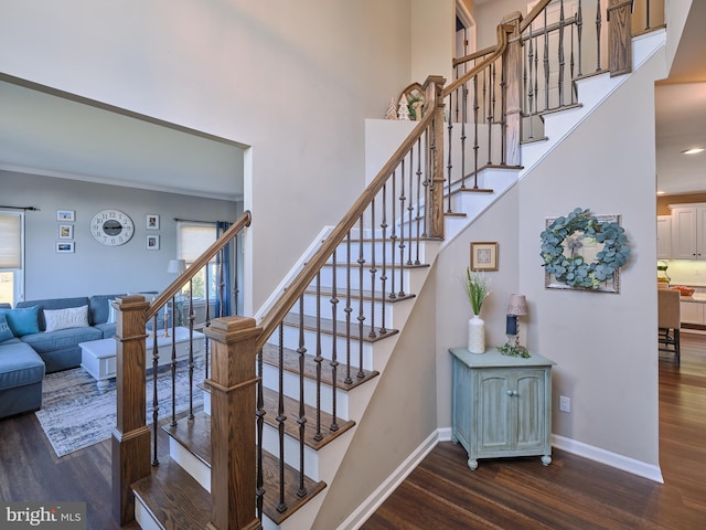 stairway featuring dark wood-type flooring and crown molding