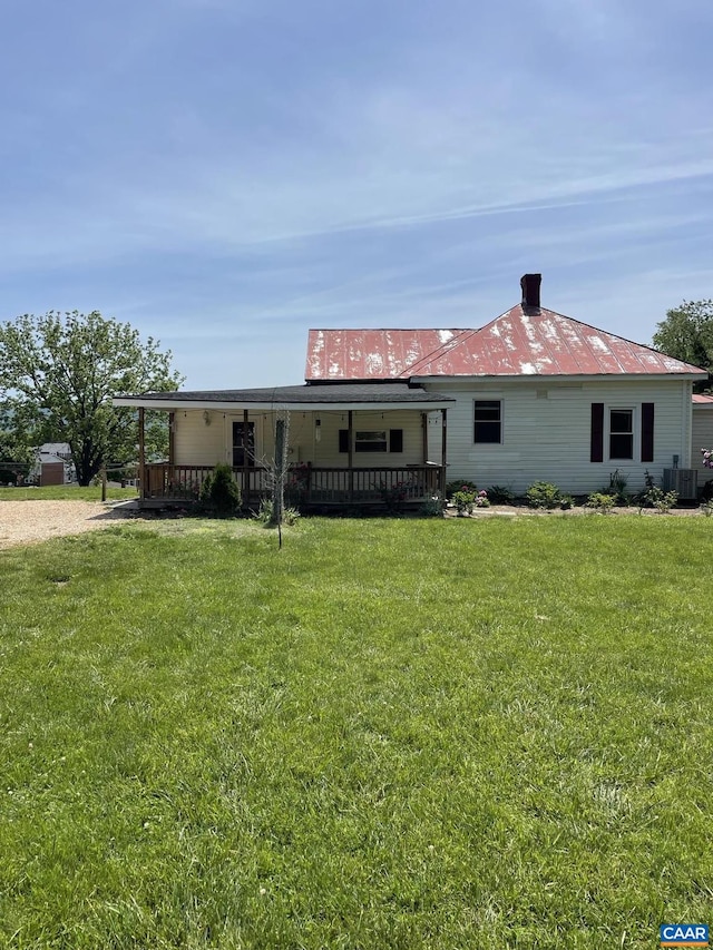 view of front of property with a front yard and central AC