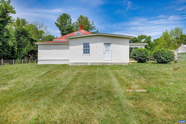 rear view of property with a yard