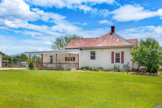 back of house with central AC unit and a lawn