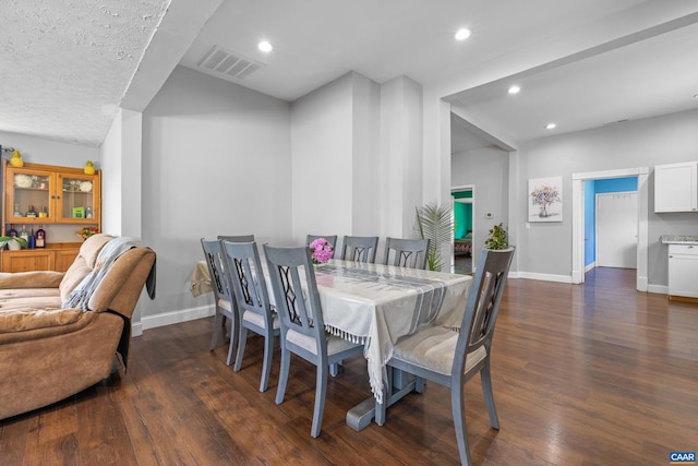 dining space featuring a textured ceiling and dark hardwood / wood-style floors