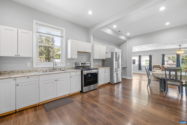 kitchen with light stone counters, dark hardwood / wood-style floors, white cabinets, sink, and appliances with stainless steel finishes