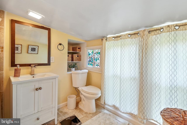 bathroom featuring vanity, lofted ceiling, and toilet