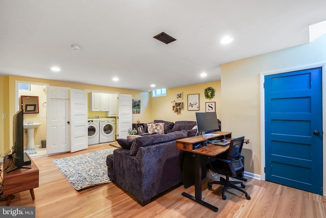 living room with light wood-type flooring and washing machine and clothes dryer