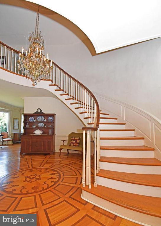 stairs featuring an inviting chandelier