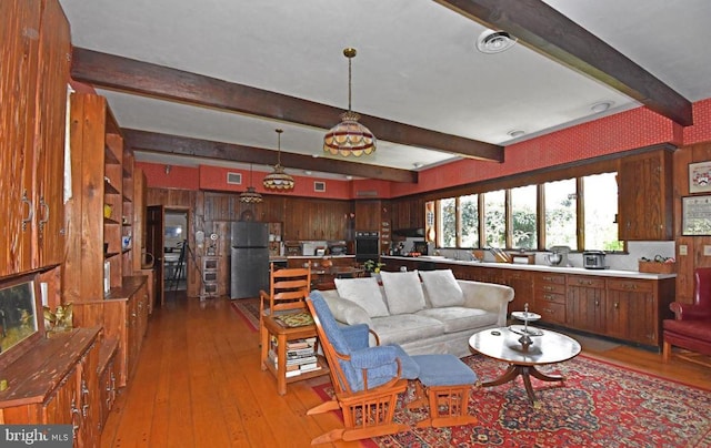 living room featuring beam ceiling and hardwood / wood-style flooring