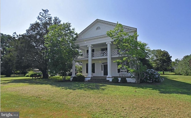 view of front facade featuring a front yard, a balcony, and covered porch