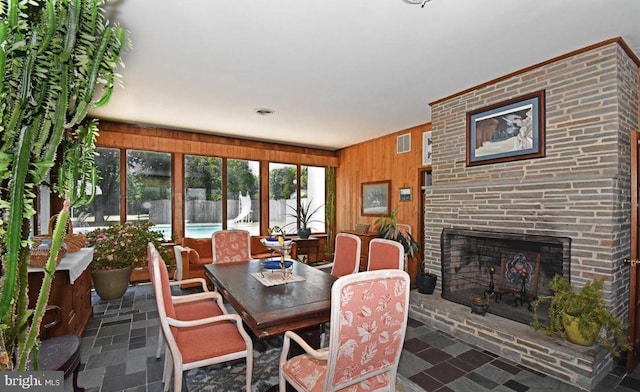 tiled dining area with a fireplace and wood walls