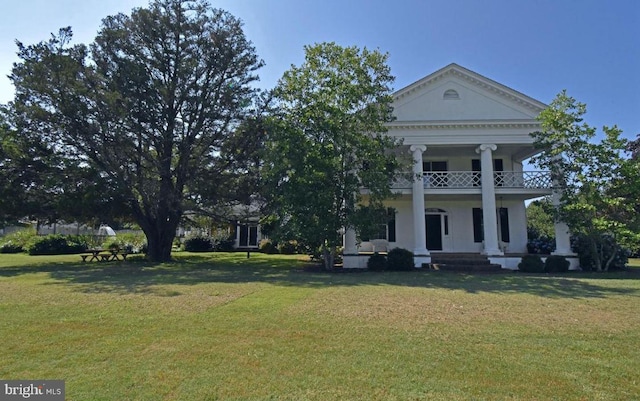 view of front of home featuring a front lawn and a balcony