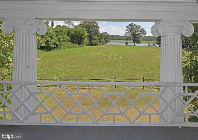 view of gate with a lawn and a water view