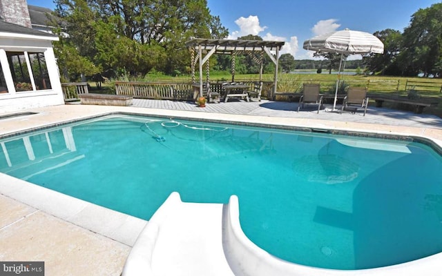 view of pool with a water slide and a pergola