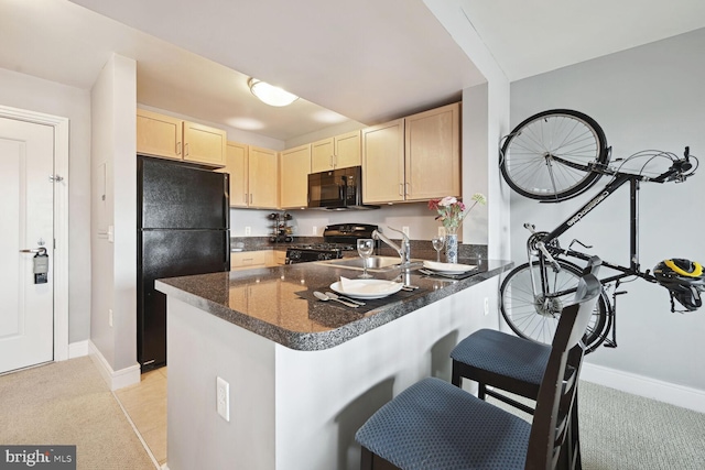 kitchen featuring sink, kitchen peninsula, light carpet, and black appliances