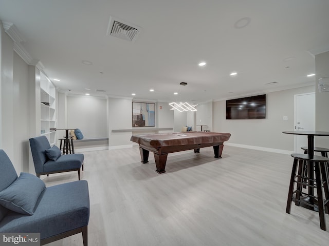 game room with pool table, ornamental molding, and light hardwood / wood-style floors