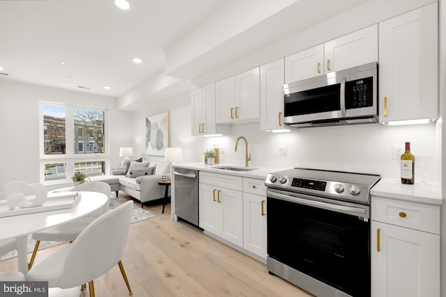 kitchen with white cabinetry, light wood-type flooring, and stainless steel appliances