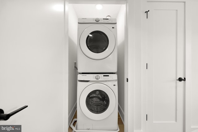 laundry area featuring wood-type flooring, washer hookup, and stacked washer and dryer