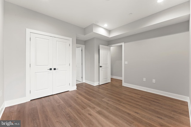 unfurnished bedroom with a closet and dark hardwood / wood-style flooring