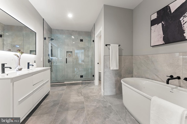 bathroom featuring tile walls, tile floors, vanity, and shower with separate bathtub