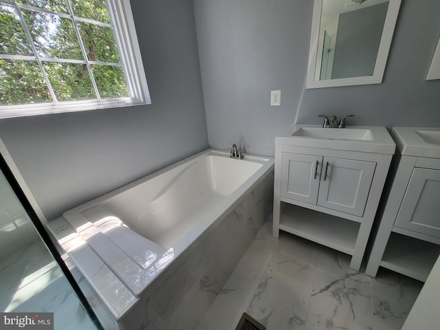 bathroom with tile flooring, a bath to relax in, washer / dryer, and vanity