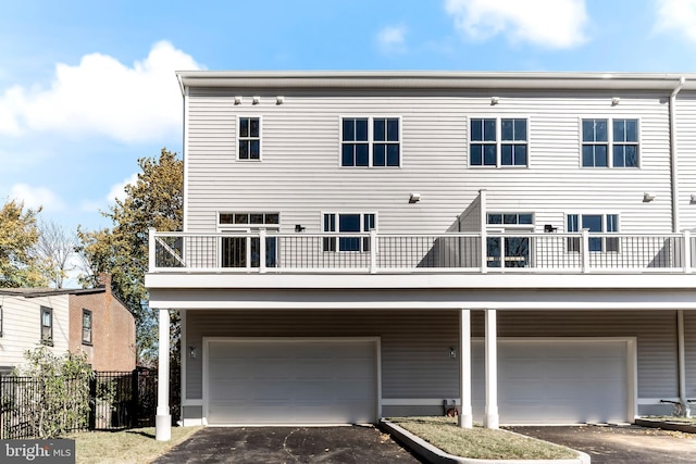 back of property featuring a balcony and a garage