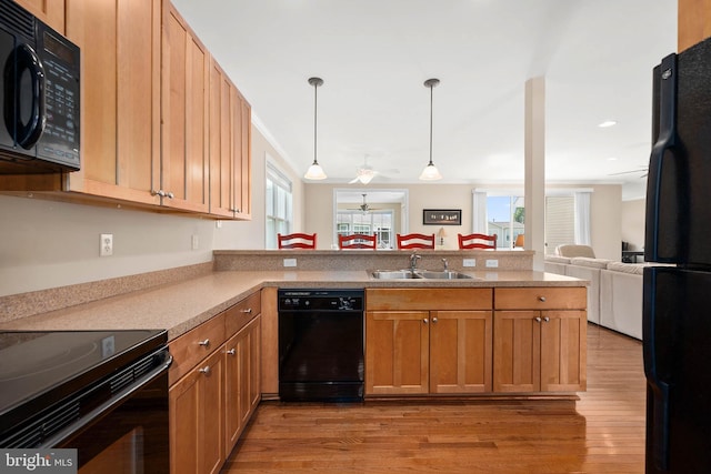 kitchen featuring sink, decorative light fixtures, kitchen peninsula, ceiling fan, and black appliances