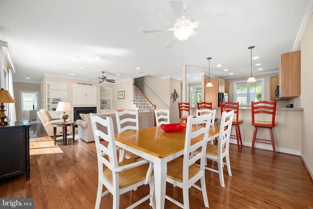 dining room with crown molding, dark hardwood / wood-style floors, and ceiling fan