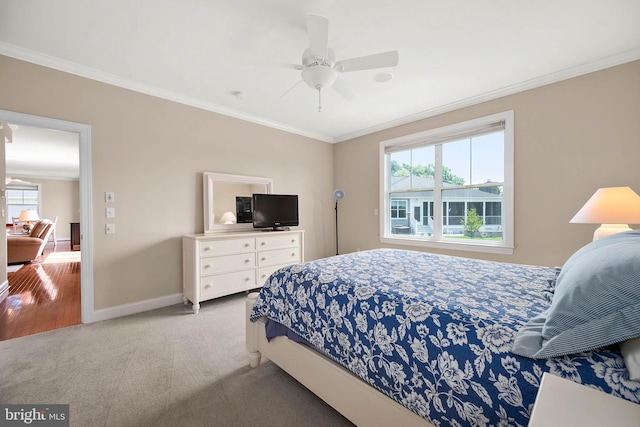 bedroom with crown molding, ceiling fan, and light colored carpet