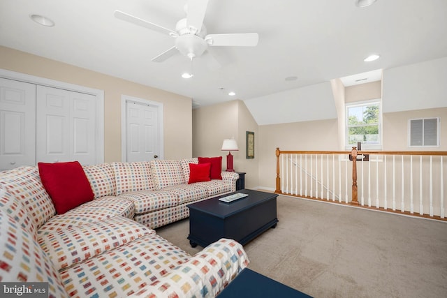 carpeted living room with ceiling fan and vaulted ceiling