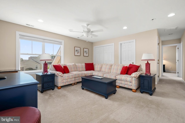 carpeted living room with ceiling fan