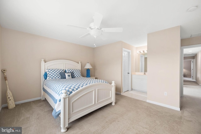 bedroom featuring ceiling fan, light carpet, and ensuite bath