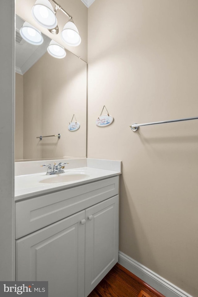 bathroom featuring vanity, hardwood / wood-style floors, and ornamental molding