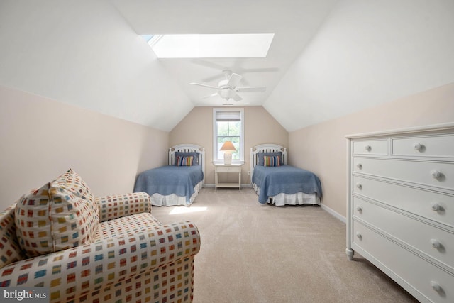 carpeted bedroom with ceiling fan and vaulted ceiling with skylight