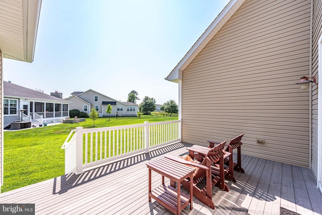 wooden terrace with a sunroom and a lawn