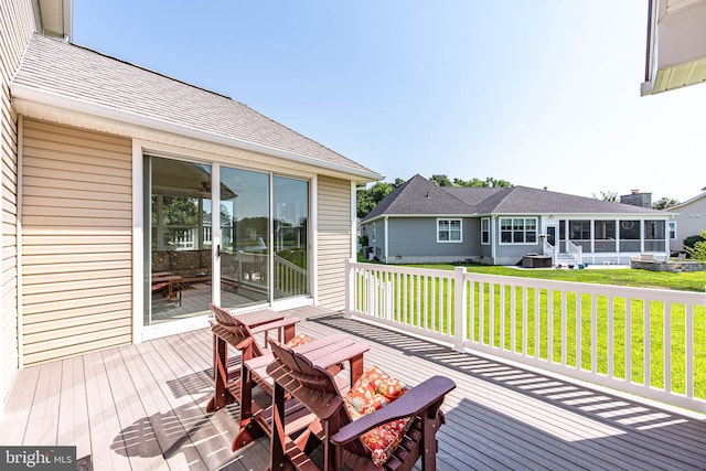 deck with a sunroom and a yard