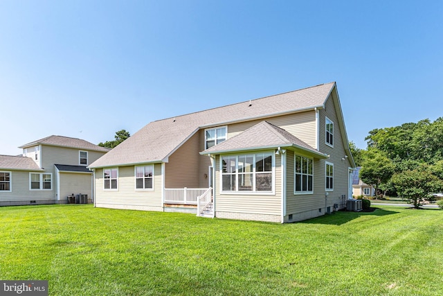 back of house with cooling unit and a yard