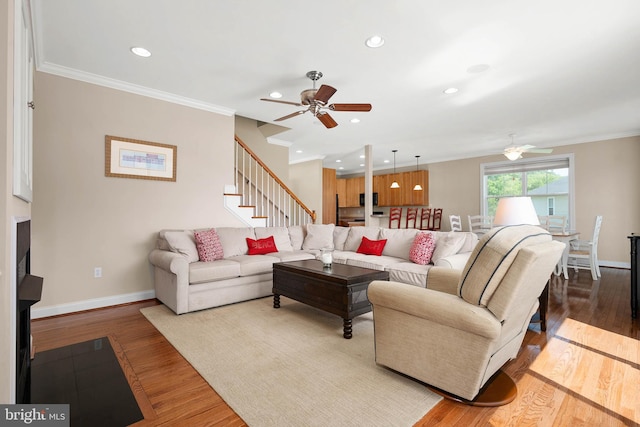 living room featuring hardwood / wood-style flooring, ceiling fan, and crown molding