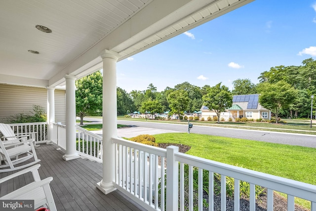 wooden deck with a porch and a yard