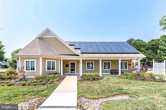 view of front of property with covered porch, a front lawn, and solar panels